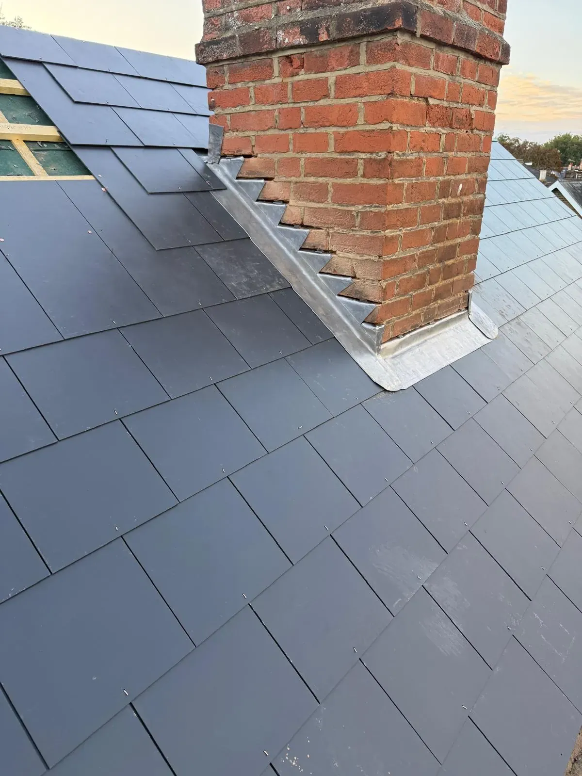 New lead flashing around a brick chimney on a slate roof