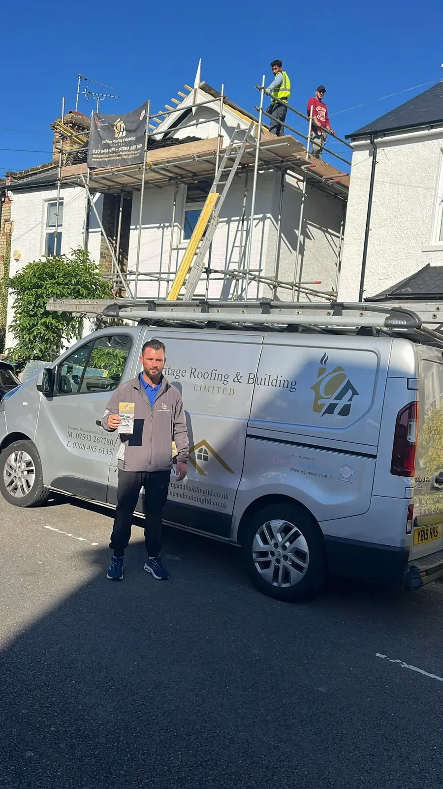 Heritage Roofing owner standing beside the company van outside a job