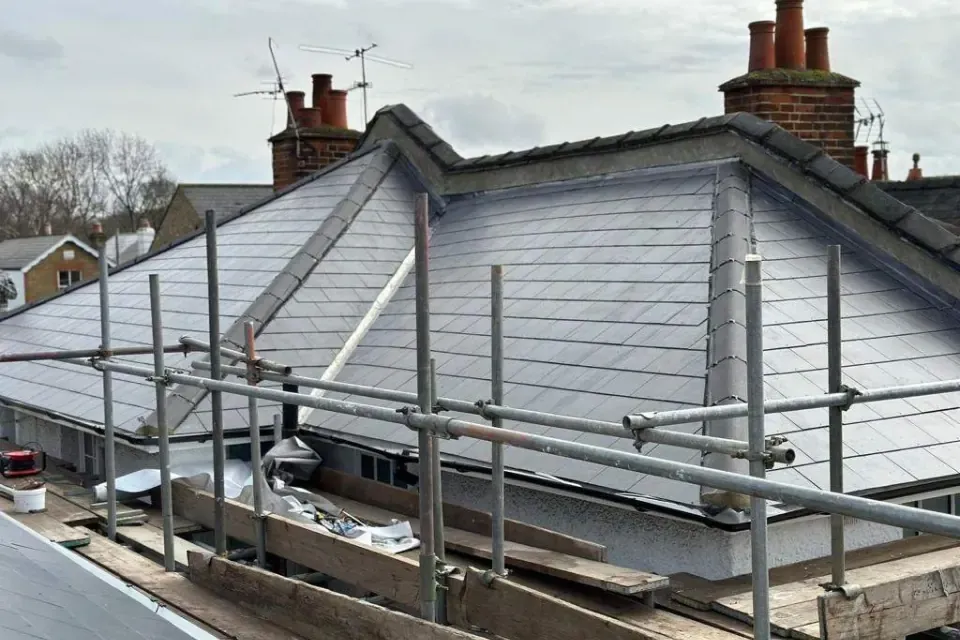 Scaffolding around a slate roof with dormers during roofing work